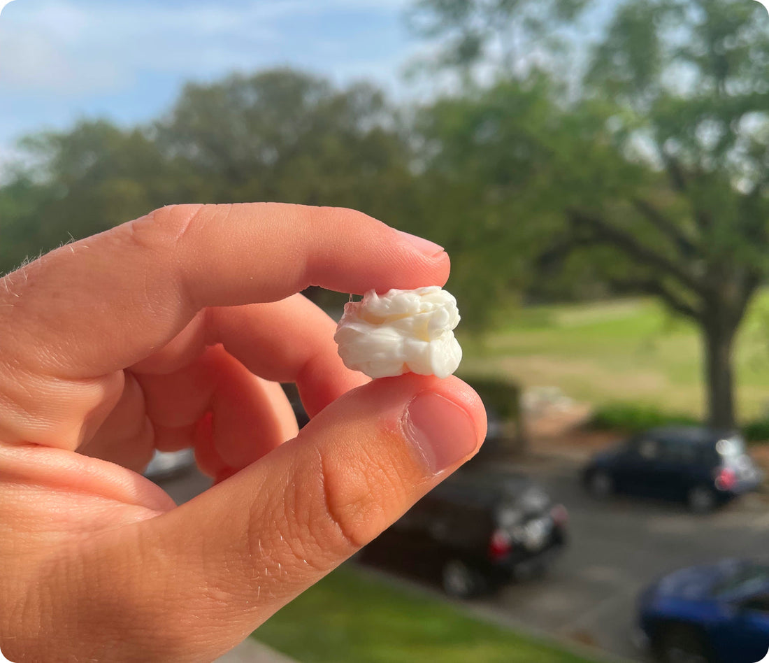 A single white Chios mastic tear held up outdoors