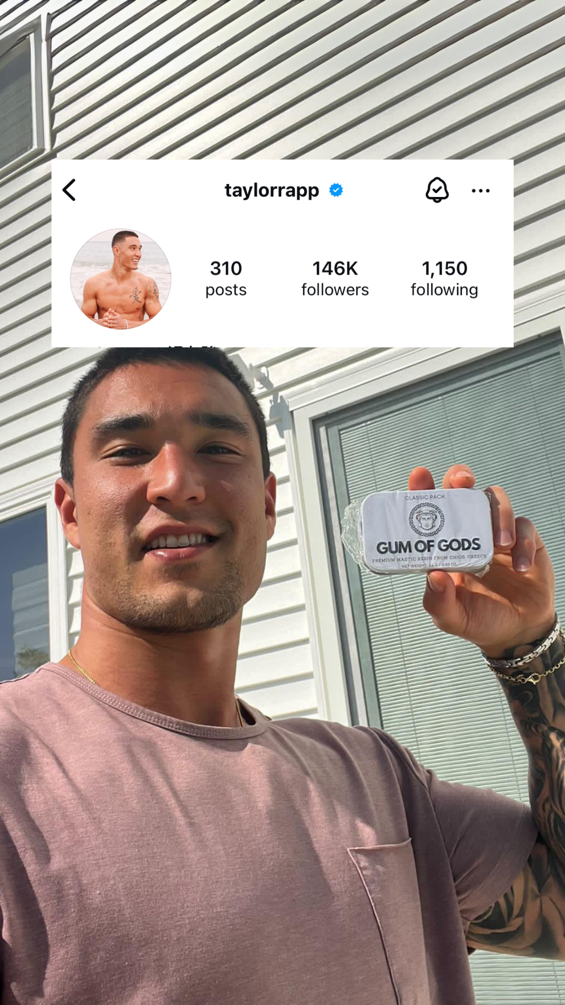 Person smiling and holding a tin labeled 'Gum of Gods' outdoors.